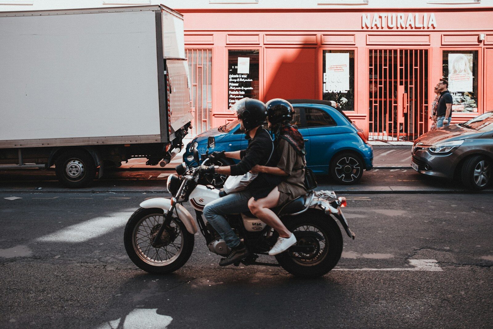 a couple of people ride on a motorcycle